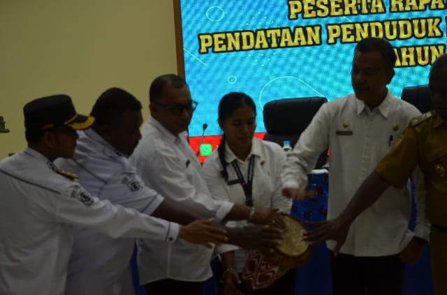 Plt. Sekda Kabupaten Jayapura di dampingi Kepala Disdukcapil dan sejumlah kepala distrik sedang menabuh tifa tanda di bukannya Rakor Pendataan Penduduk Kabupaten Jayapura Tahun 2025